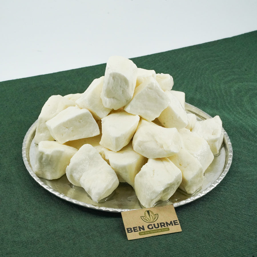 Bidon içinde, salamura suyuyla bekletilen taze Antep keçi peyniri dilimleri.