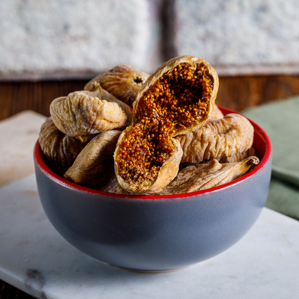 Ben Gurme'nin Aydın Kuru İncirleri, hasır sepet içinde doğal ve taze görünümüyle yakın çekimde. İncirlerin bal rengi ve hafif pürüzlü yüzeyleri belirgin, doğallığı ve lezzeti vurgulanıyor.