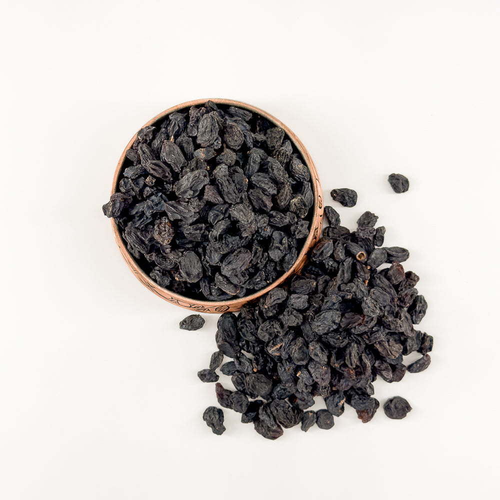 Bakır kapta sunulan doğal ve kaliteli siyah kuru üzüm.