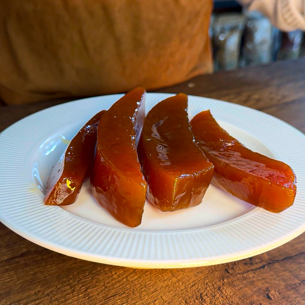 Beyaz porselen tabağa servis edilmiş parlak görünümde 3 dilim kabak tatlısı.