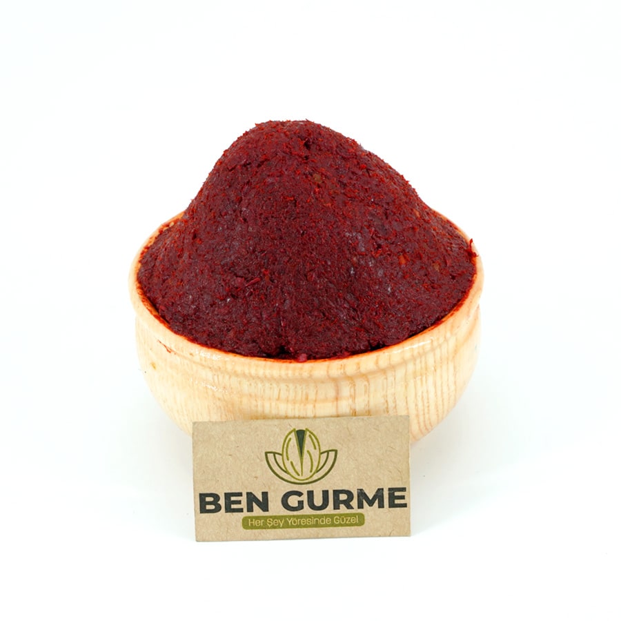 Ahşap kase içinde koyu kırmızı renkli doğal tatlı biber salçası.