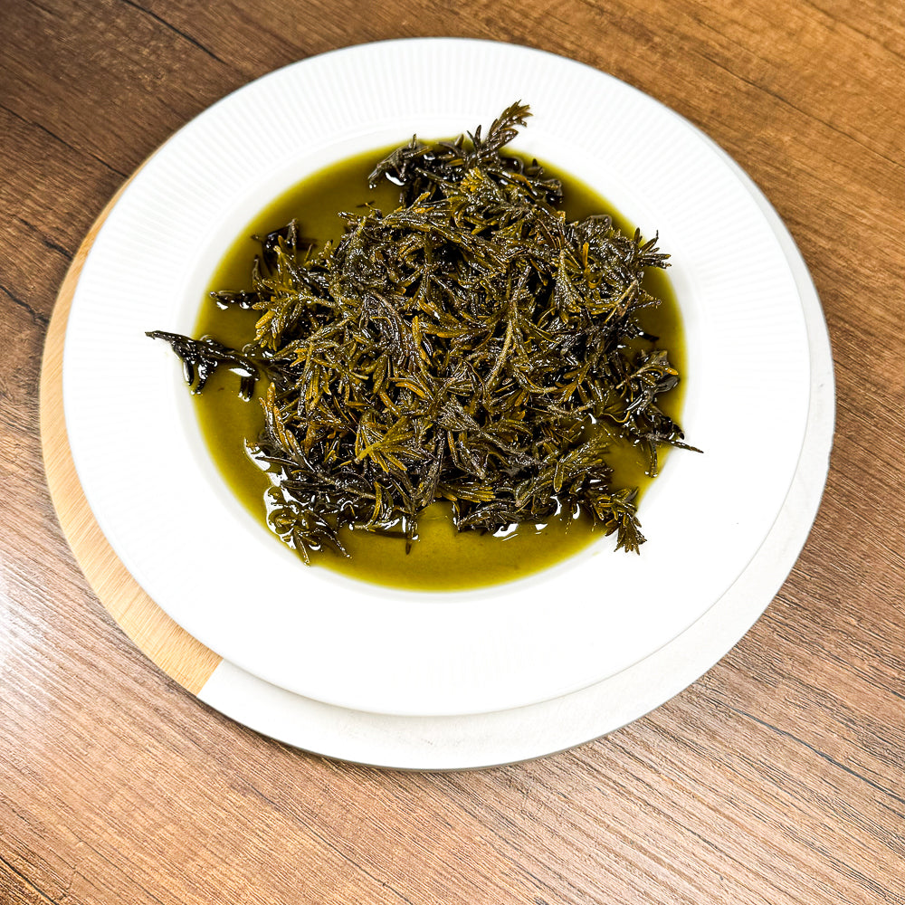 Beyaz tabakta servis edilen zeytinyağıyla hazırlanmış dağ kekiği