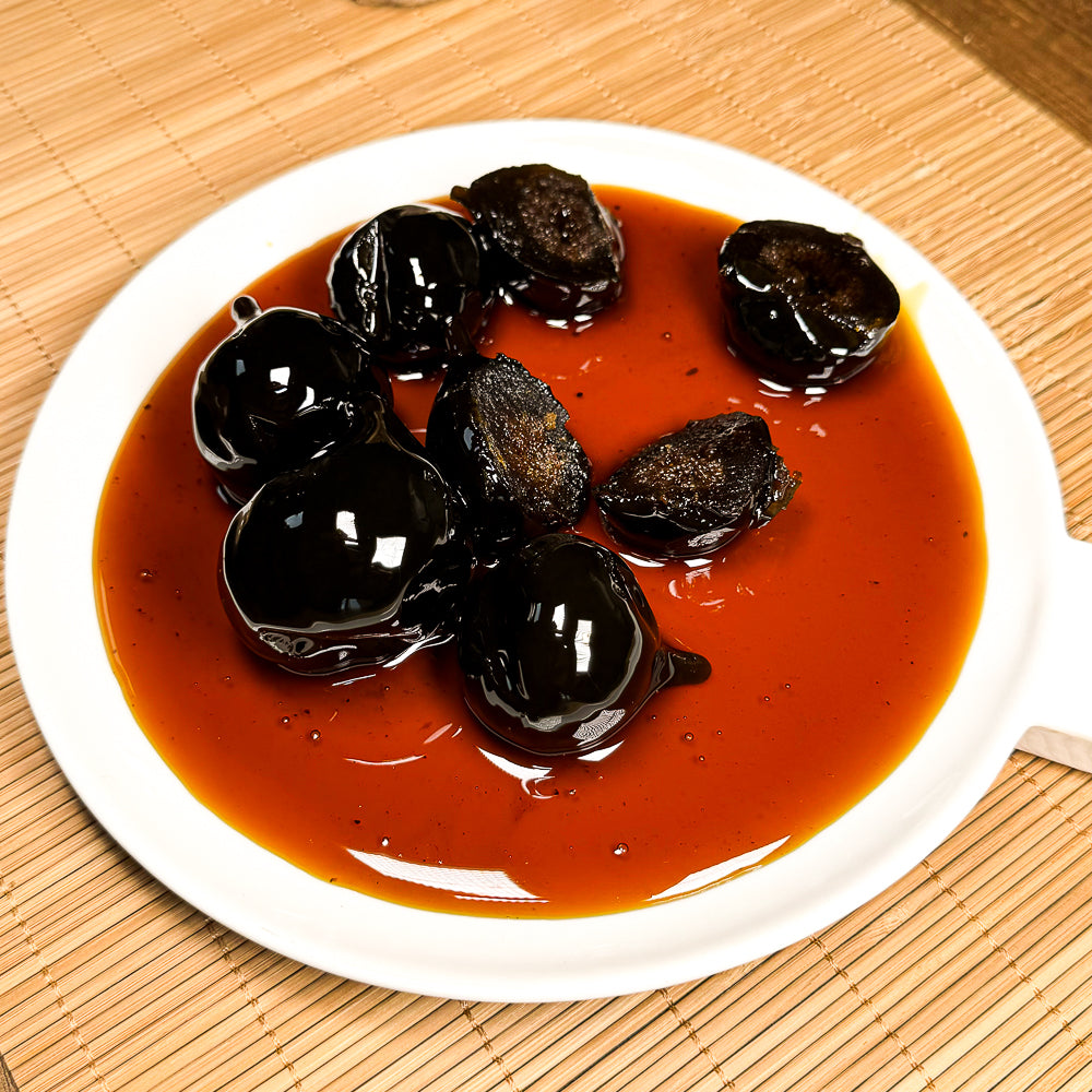 Bambu dokulu zemin üzerine yerleştirilmiş beyaz tabakta dökülmüş kıvamlı kahverengi sos.